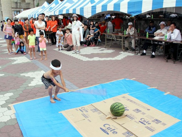 かけ声に合せて親子でスイカ割り